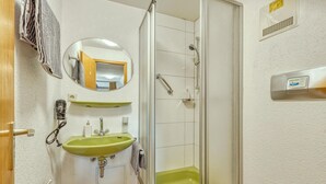 A bathroom with a green sink, a mirror, a shower, and a toilet. - Nice apartment in Bischofsheim (Bischofsheim)