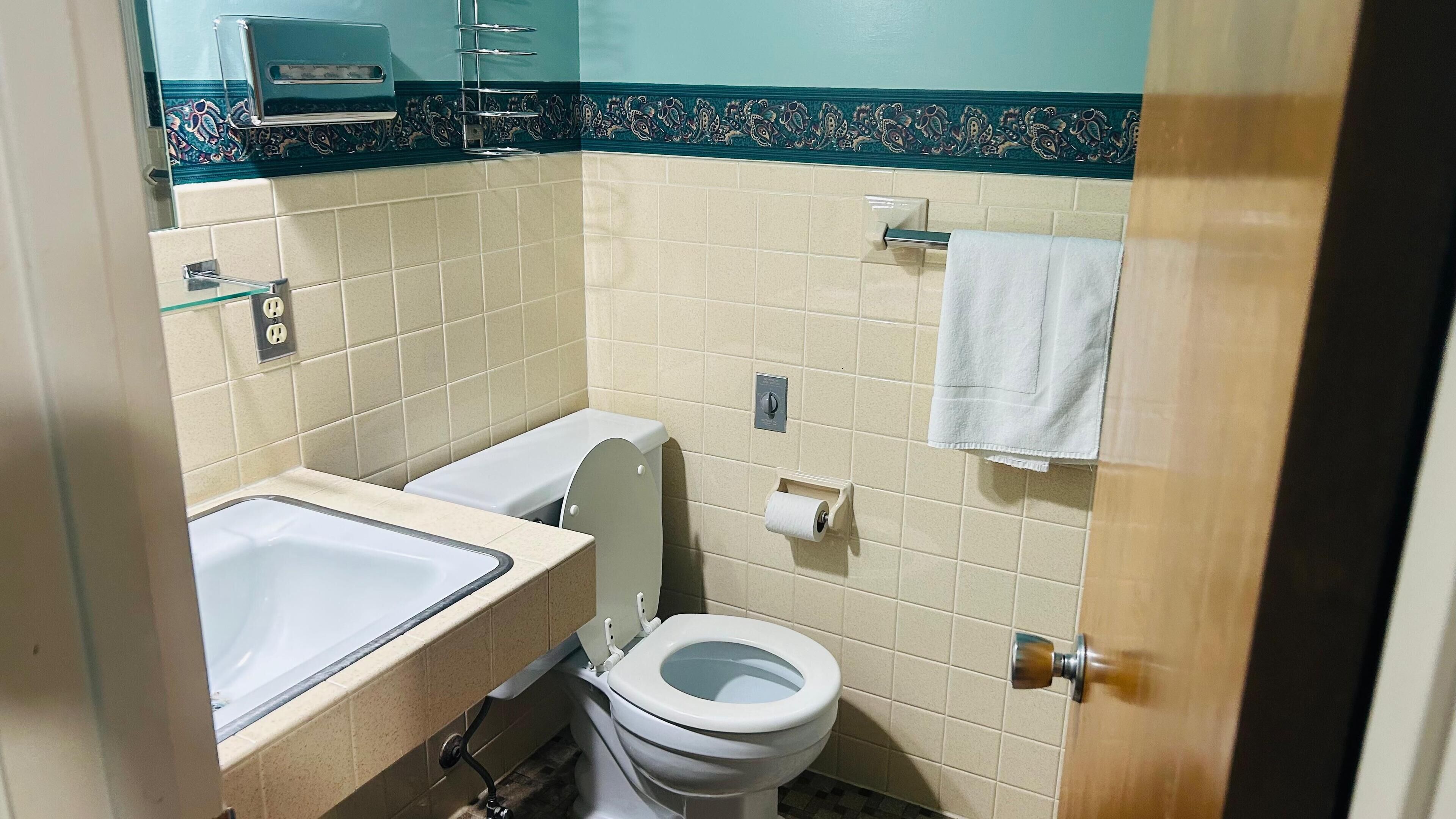 A small bathroom with a toilet, sink, and towel rack.