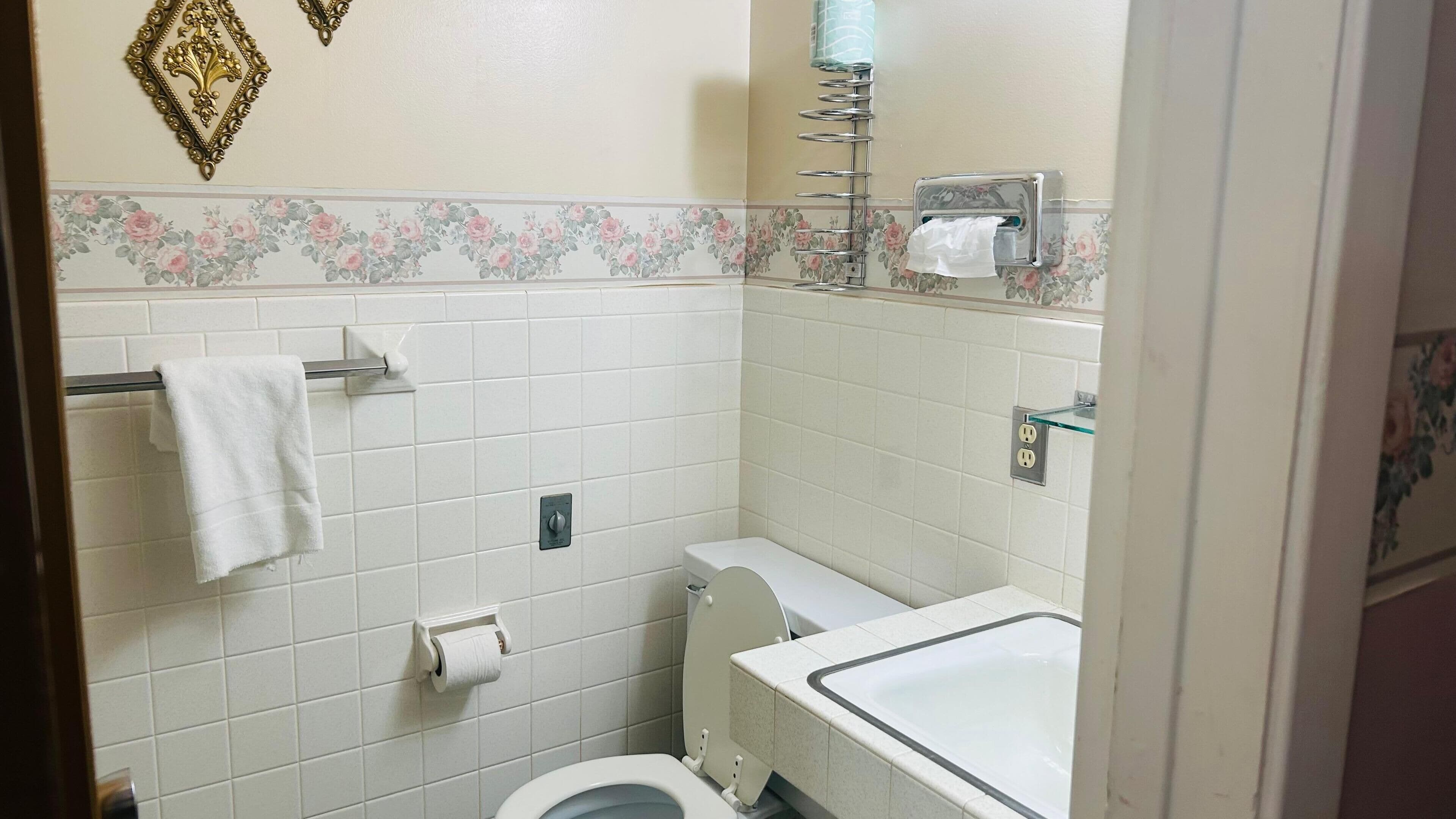 A small bathroom with a toilet, sink, and towel rack.