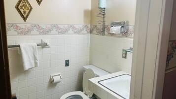 A small bathroom with a toilet, sink, and towel rack.
