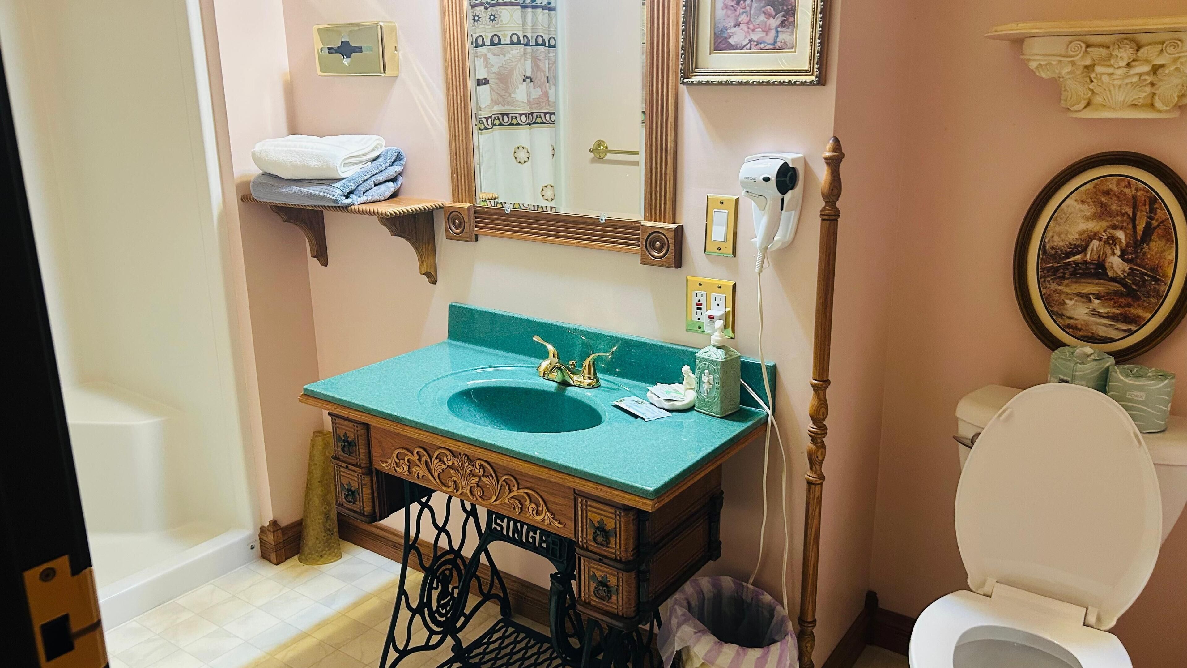 Un baño con un lavamanos antiguo, un inodoro y un espejo.