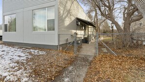A single-story building with a covered porch and a gated entrance. - Charming 1-Bedroom  Apartment in Great Neighborhood (Great Falls)