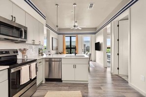 A modern kitchen with stainless steel appliances, a dishwasher, and a central island. - Music Row 2BR, 3 Beds | Free Gated Parking (Nashville)