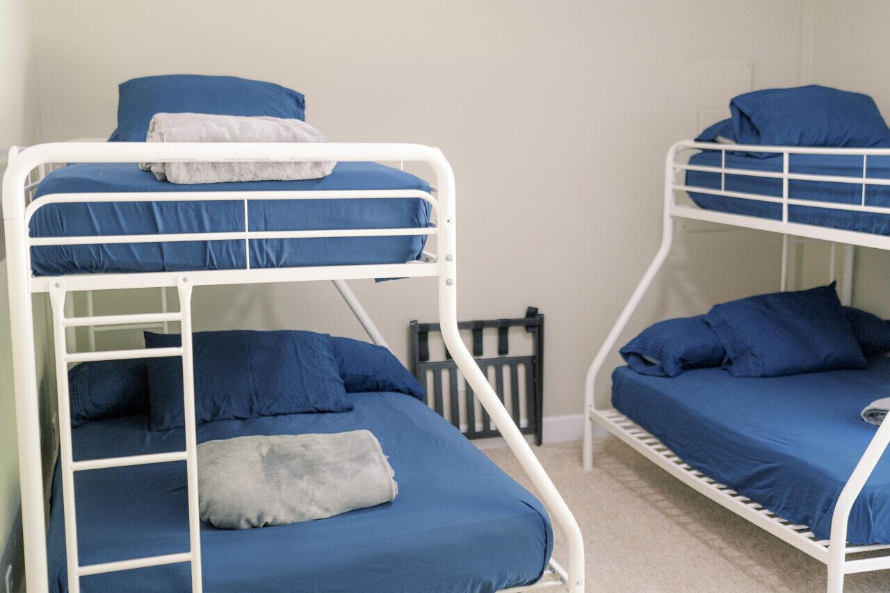 Habitación con literas, dos camas, cada una con ropa de cama y almohadas azules.