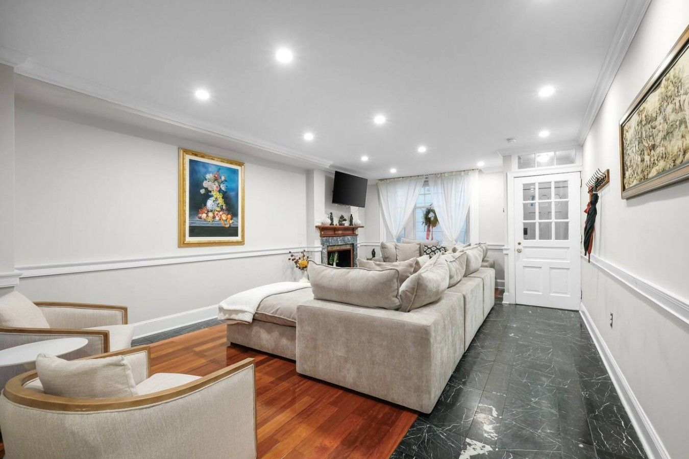 A spacious living room with a beige sofa set, a wooden coffee table, and a fireplace.