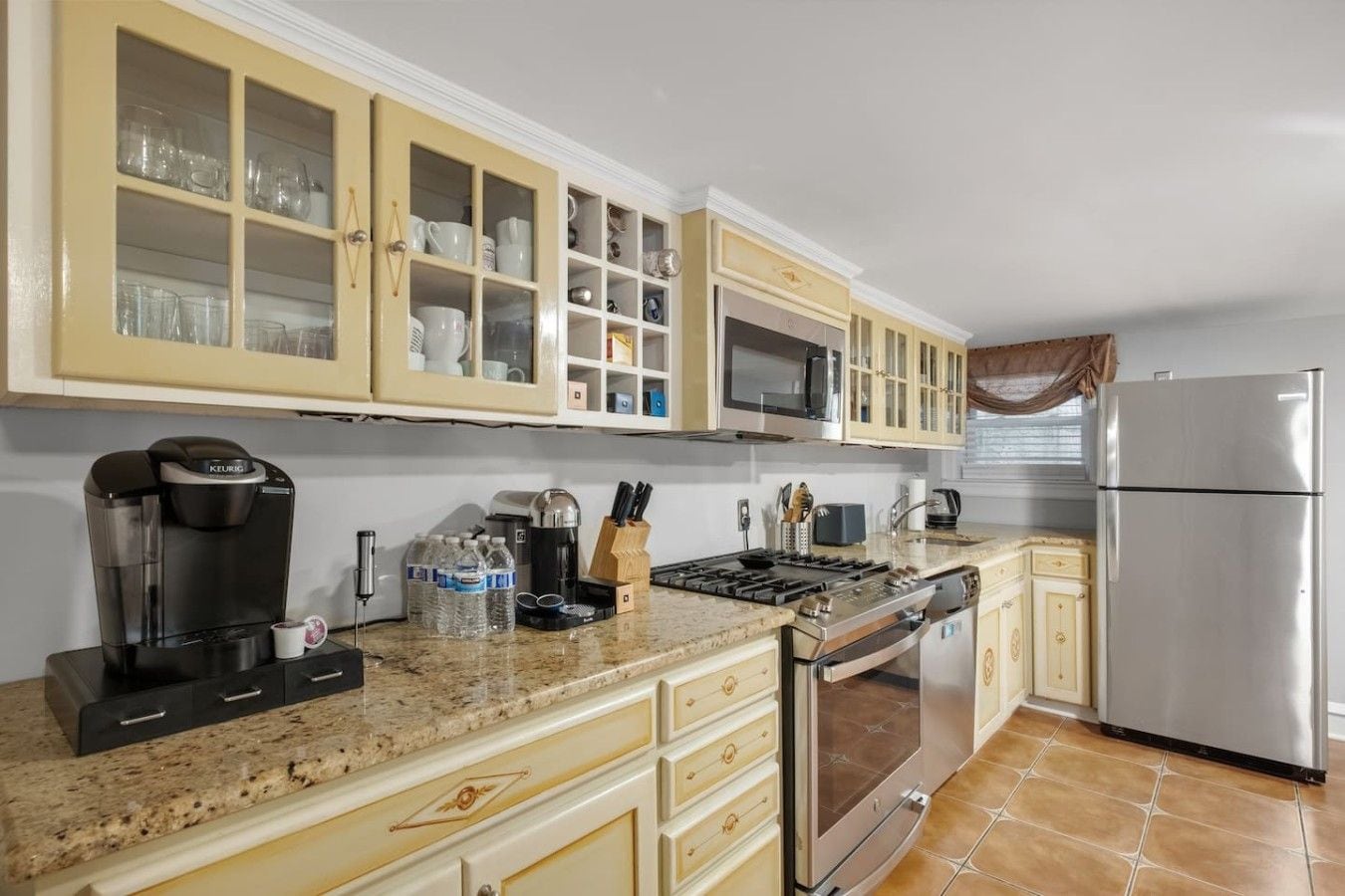 A kitchen with a built-in microwave, stainless steel appliances, and a refrigerator.