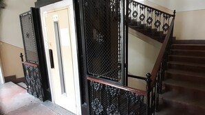 Eine Treppe mit schwarzer Metallgeländer und einem Holzhandlauf.