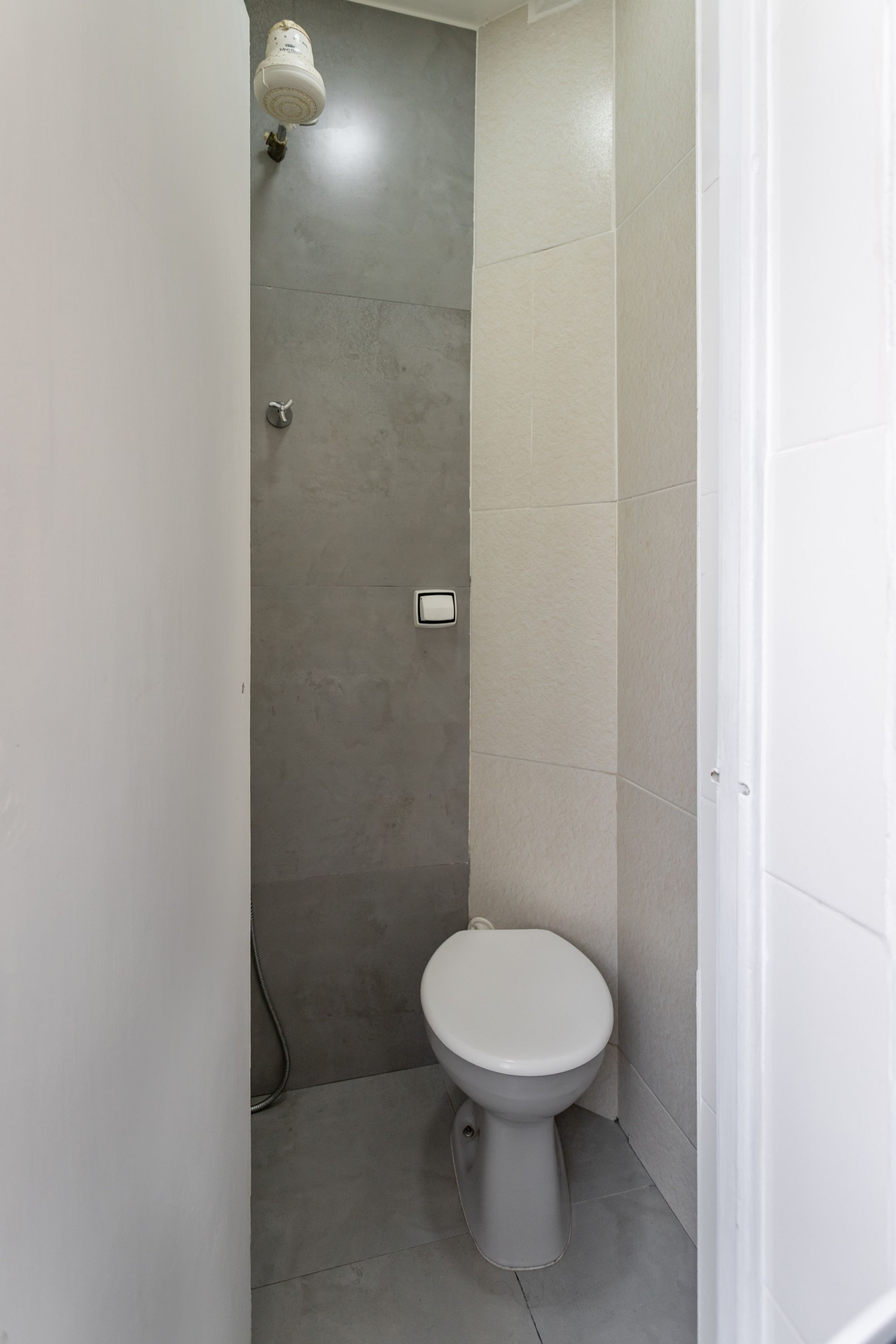 Un baño pequeño y moderno con inodoro y cabina de ducha.