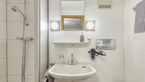 A bathroom with a shower, sink, and toilet.