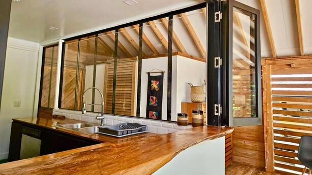A kitchen with a wooden countertop, a sink, and a window with a view of the interior. - Jungle House, 100m From the Beach, With Private Pool (Bocas del Toro)
