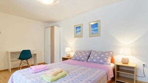 Ein Schlafzimmer mit einem Bett, Nachttischen, einem Schreibtisch und einem Sessel.