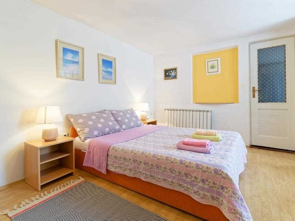 Ein Schlafzimmer mit Bett, Nachttischen, Heizkörper und Tür.