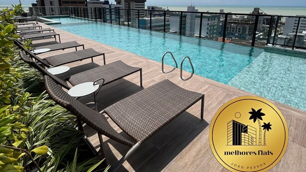 A rooftop pool with lounge chairs and a view of the city skyline. - Melhores Flats - Perfeição perto do mar (João Pessoa)