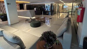 A modern lobby with a reception desk, seating area, and a 'MOVE' sign. - Melhores Flats - Perfeição perto do mar (João Pessoa)