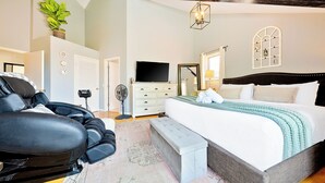 A bedroom with a large bed, a massage chair, a TV, and a small desk. - La Jolla Beach House. 2 Minute Walk to the Beach! (San Diego)