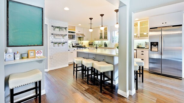 A modern kitchen with a central island, bar stools, a stainless steel refrigerator, and pendant lighting. - La Jolla Beach House. 2 Minute Walk to the Beach! (San Diego)