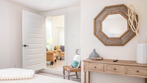 A bedroom with a bed, a dresser, a mirror, and a chair. - Lakeside Retreat – 6BR, Huge Backyard, Private Sandy Beach Access! (Denison)