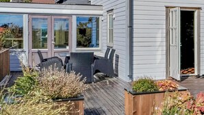 A house with a covered patio area featuring outdoor furniture and planters. - 3 bedroom stunning home in Avaldsnes (Avaldsnes)