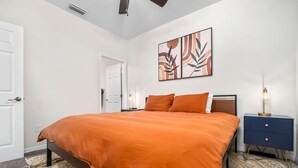 A bedroom with a bed, a nightstand, a lamp, and a door. - Beautiful Home - Walk to UF - Newly built (Gainesville)