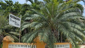 A sign for Richmond Beach Club with a palm tree backdrop. - Don Juan Bungalow (Ocho Rios)