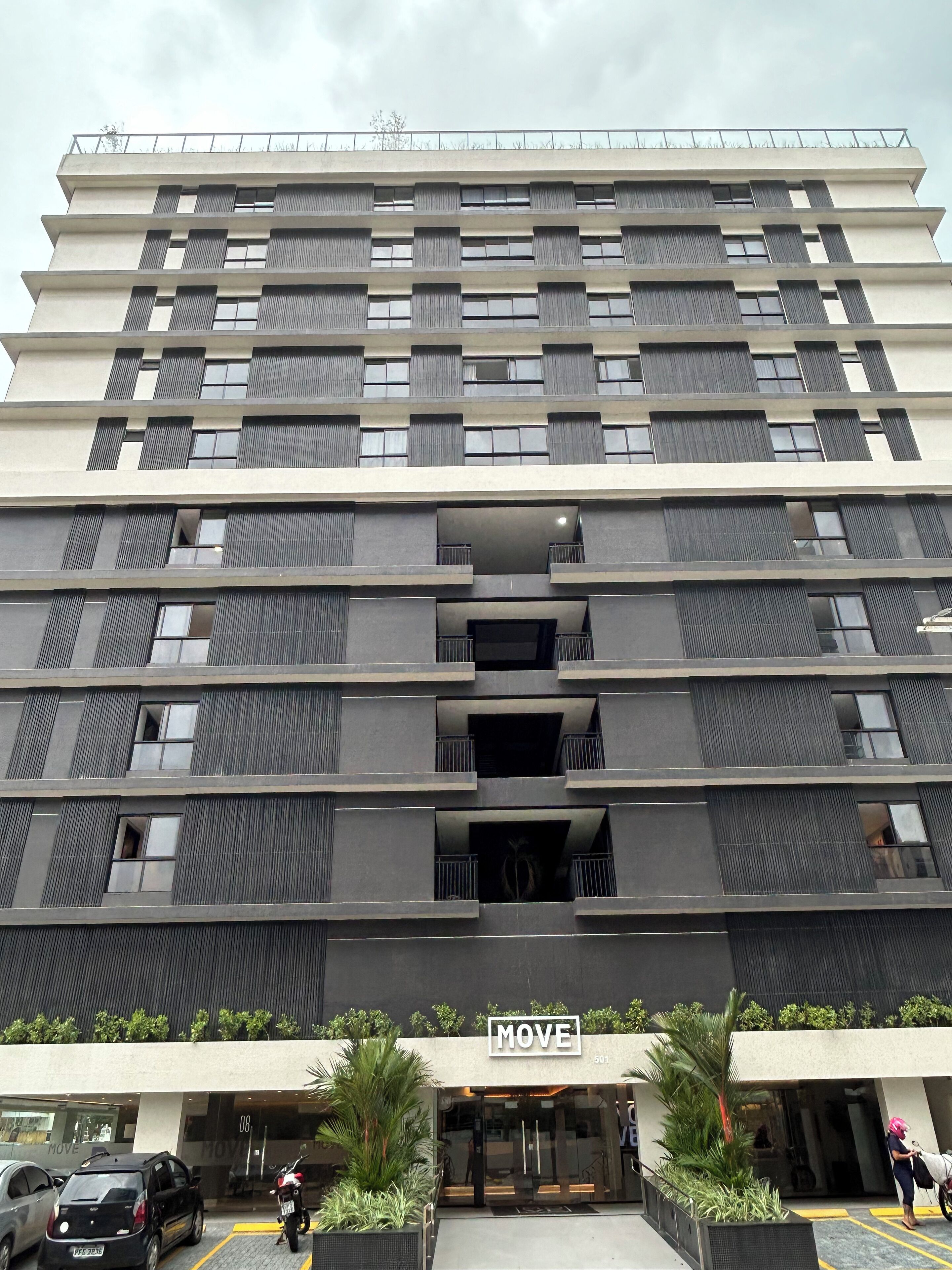 A multi-story building with a modern architectural design, featuring a prominent entrance with a sign reading "MOVE".