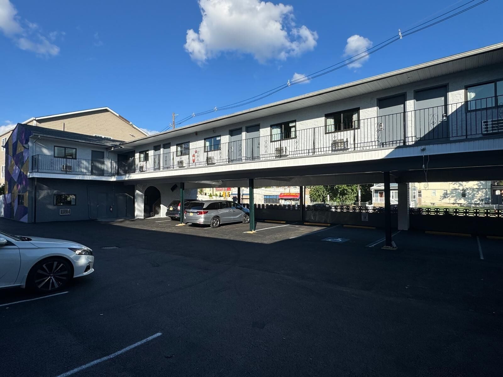 Un motel à deux étages doté d’un espace de stationnement couvert et d’un bâtiment d’un seul étage attenant.