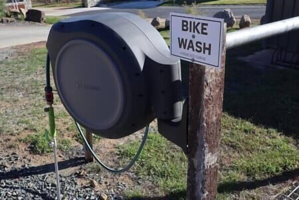 Una estación de lavado de bicicletas con un cartel.