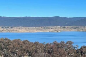 A landscape with a large body of water and distant hills. - 3 brand new cabins with great views (East Jindabyne)