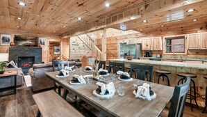 Ein Holzblockhaus-Interieur mit Essbereich, Küche und Wohnzimmer.