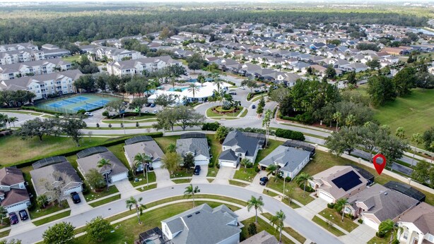 An aerial view of a residential area with houses, a tennis court, and a swimming pool. - Tranquility Palms Four Bedrooms in Windsor Palms Resort - Steps to Disney (Kissimmee)