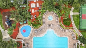 An aerial view of a resort with a large central pool, smaller pools, and various seating areas surrounded by greenery. - Tranquility Palms Four Bedrooms in Windsor Palms Resort - Steps to Disney (Kissimmee)
