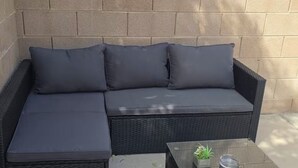 A sectional sofa with a chaise, a glass coffee table, and a small potted plant. - Cozy 3 bedrooms, Sleeps 8 people.4605 Possum Berry Ln. North Las Vegas NVD.89081 (North Las Vegas)