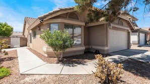 A single-story house with a garage, a small front yard, and a tree. - Cozy 3 bedrooms, Sleeps 8 people.4605 Possum Berry Ln. North Las Vegas NVD.89081 (North Las Vegas)