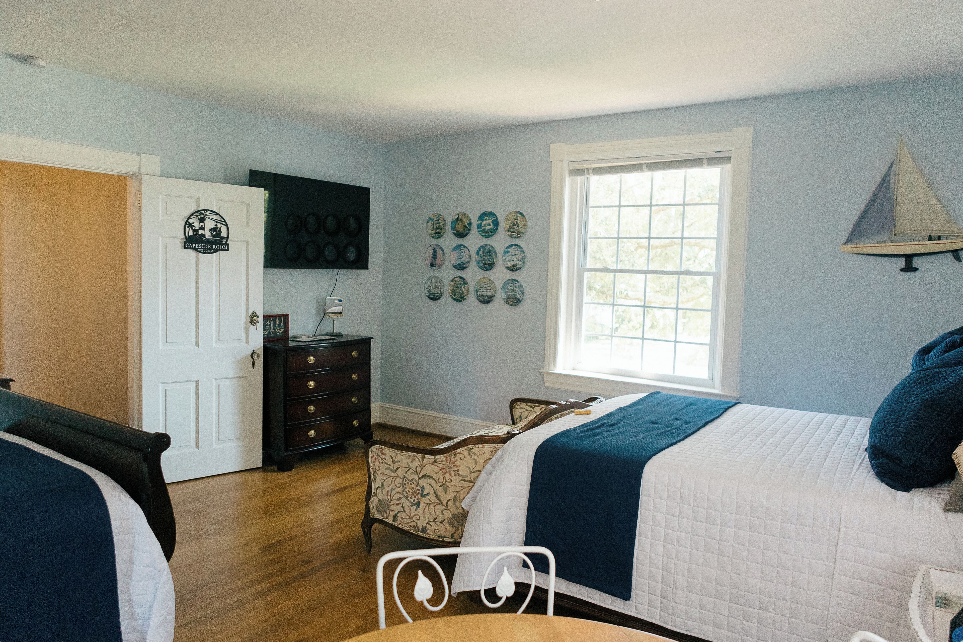 A bedroom with a bed, dresser, and a window.