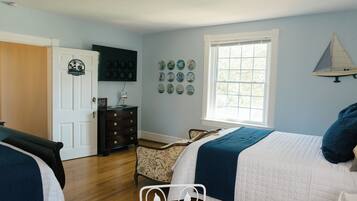 A bedroom with a bed, dresser, and a window.