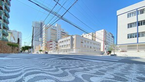 Une rue de la ville, avec des immeubles, un passage piéton et des lignes électriques.