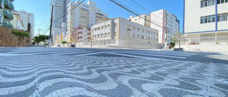 A city street with buildings, a crosswalk, and power lines.