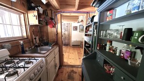 A compact kitchen with wooden cabinets, a stove, and a sink.
