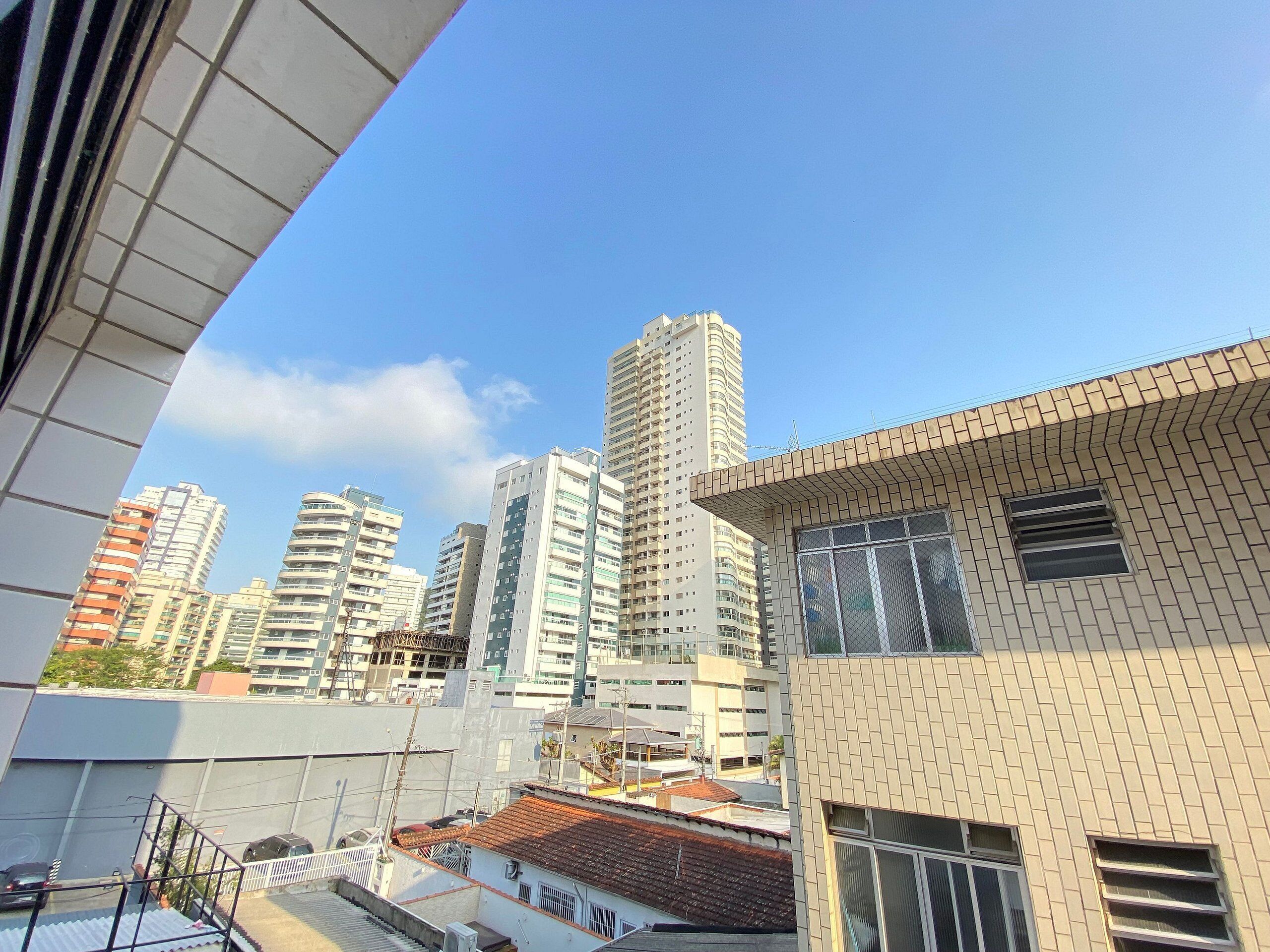A high-rise building with multiple floors, large windows, and a clear sky.