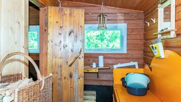 Interno accogliente di una baita rustica, con una porta in legno, una finestra vista e un divano giallo, più un cesto in vimini.