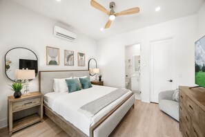 A bedroom with a bed, bedside tables, a ceiling fan, and a TV.