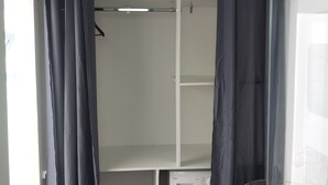 Ein Waschbereich mit Waschmaschine, Wäscheständer und Holztisch.