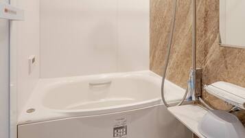 A modern bathroom with a bathtub, a shower, and a vanity with a mirror.