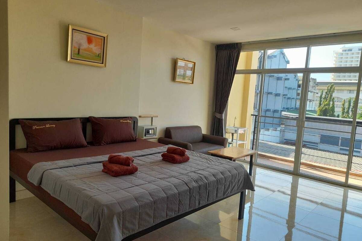 Relax in a stylish room with a large bed, sofa, and city view.