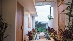 A modern hallway with a water feature, potted plants, and a statue. - Private Villa with butler service surrounded by rice fields and jungle views. (KAB. GIANYAR)
