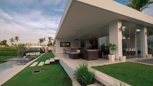 A modern house with a covered patio, outdoor seating, and a swimming pool. - Private Villa with butler service surrounded by rice fields and jungle views. (KAB. GIANYAR)
