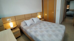 A neatly arranged hotel room with a bed, bedside lamps, a nightstand, and a wardrobe. - ACV - Torremar-2ª Linea Planta 3 Sur (OROPESA)