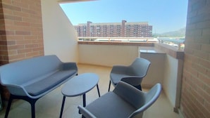 A balcony with a sofa, two chairs, and a small table. - ACV - Torremar-2ª Linea Planta 3 Sur (OROPESA)