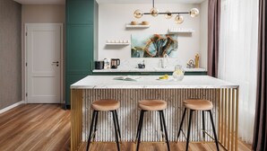 A modern kitchen with a marble countertop, three stools, and a hanging light fixture. - DA-LI Residence - AC and Netflix (Brașov)