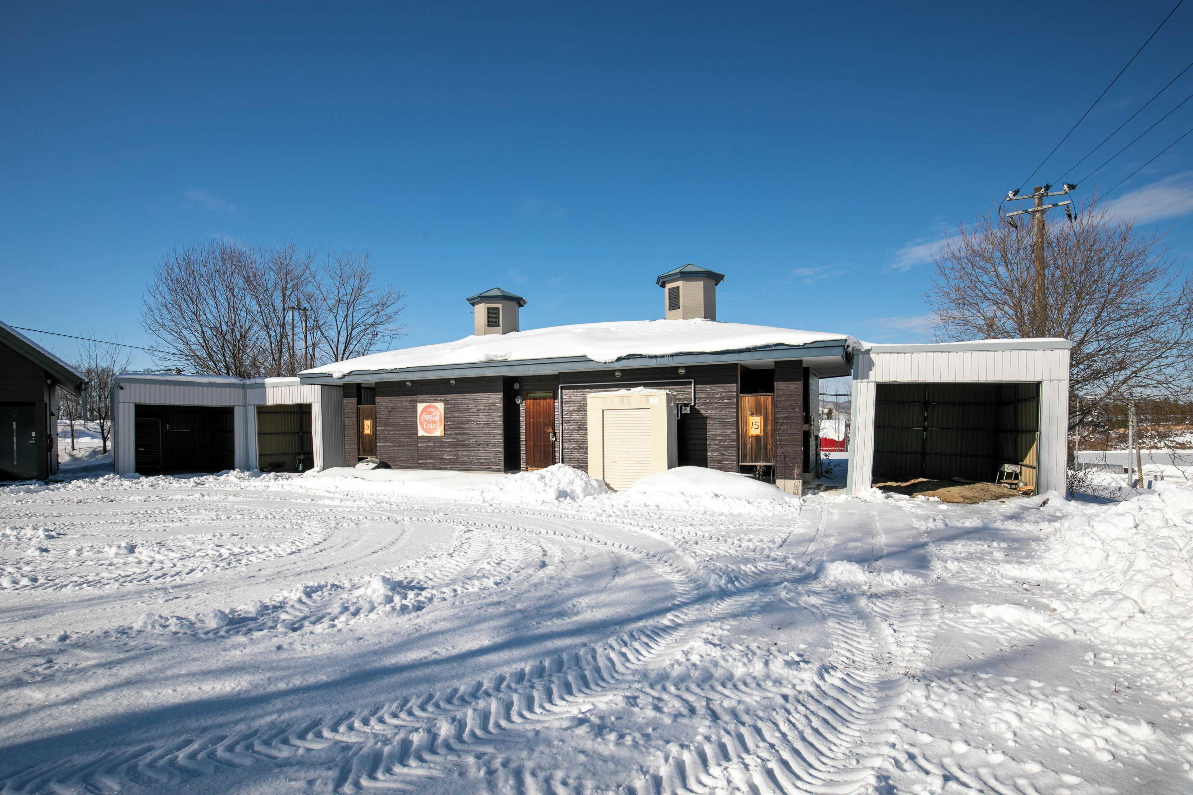 Un bâtiment dont le toit est recouvert de neige et qui possède une porte de garage.